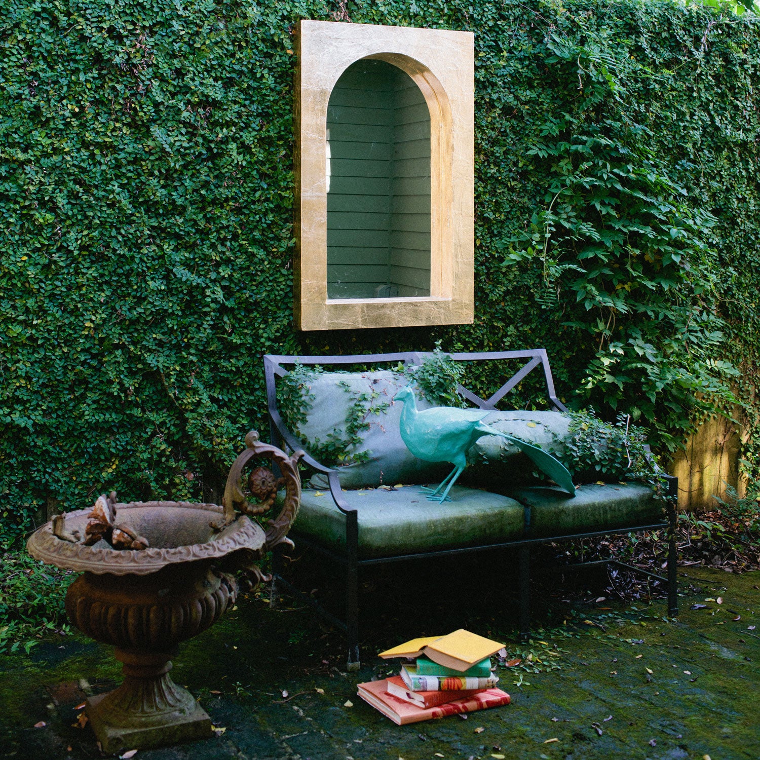 Papier Mache Peacock preening in beautiful walled garden.